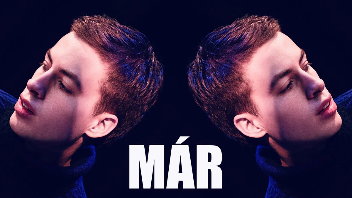 The Icelandic star Már. are reflected. Blue sweater, Már. has brown with hint of red hair. On the bottom of the picture , centred text : Már. in white capital letters. This pictures are a port of Már's. single cover for the single "Falling for You"